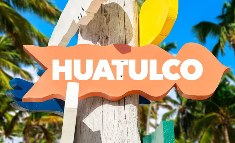Huatulco welcome sign with palm trees