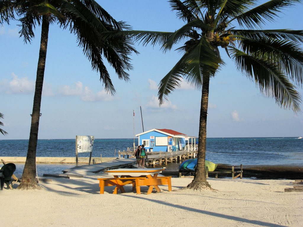 A colorful dock on a white sand beach