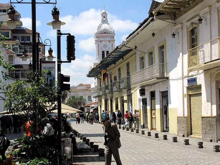 People walkingin a cobblestoned street with colonial style buildings