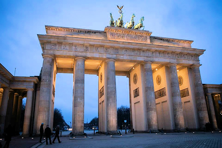 A view of thelit up Brandenberg Gate at dusk