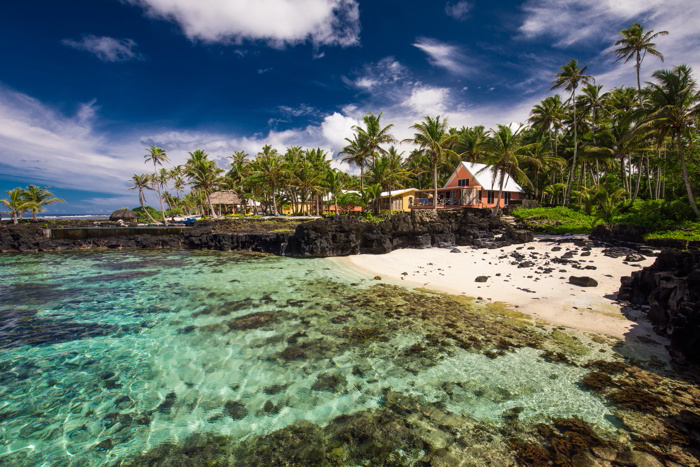 Tropical beach on south side of Samoa Island with coconut palm trees