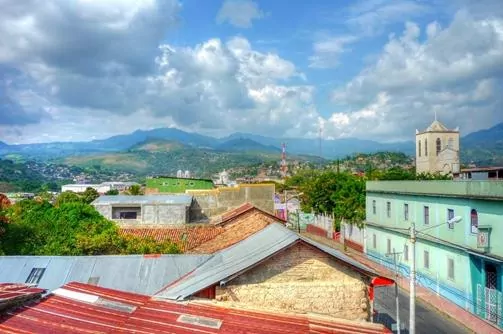 Matagalpa, Nicaragua. View over rooftops to the mounitains. Blue sky and lush green Nicuraguan countryside