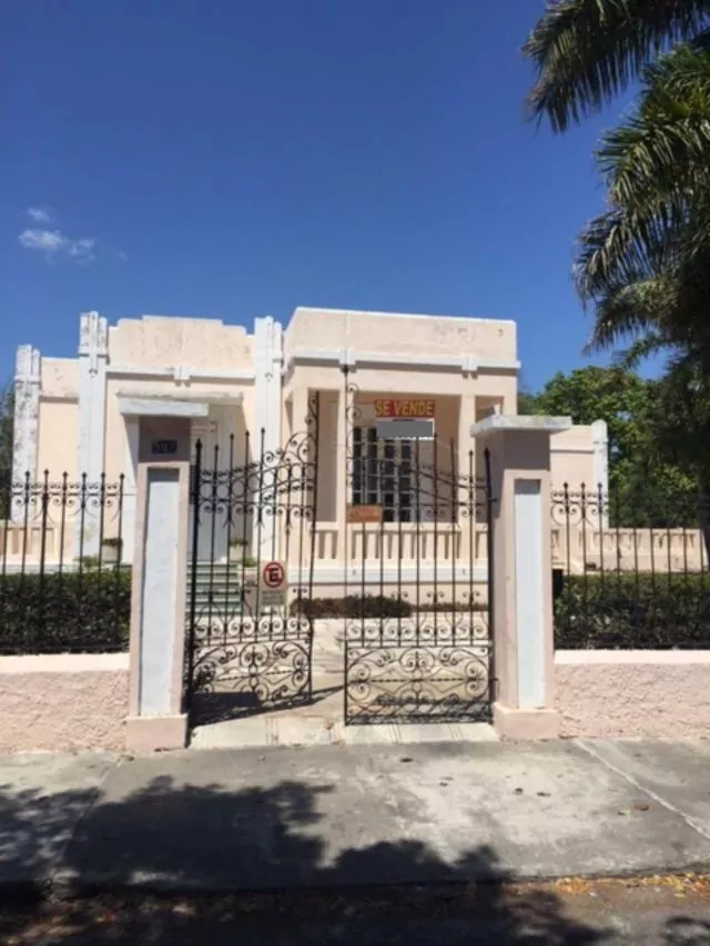 mansion in merida, mexico for sale at over 1 million dollars. mansion is light stone and sits behind ornate gates