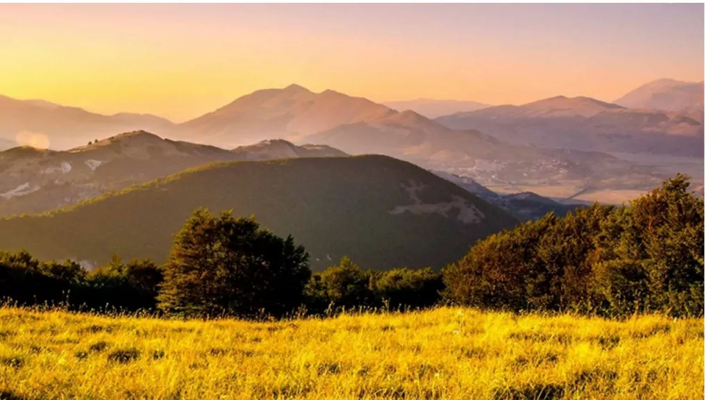 Italian hills at sunset with mountains in the background