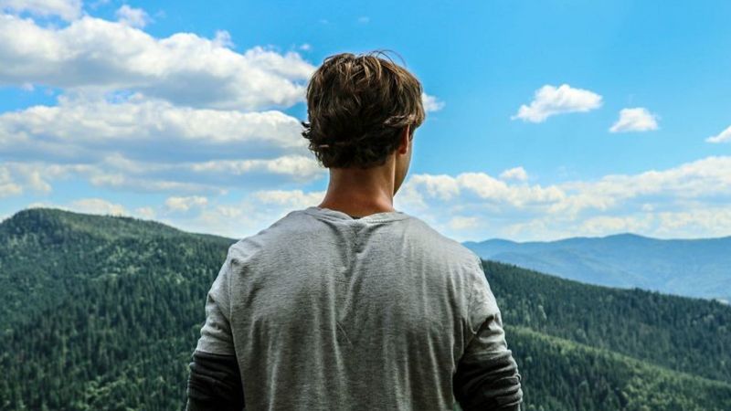 person looking out across a mountain range