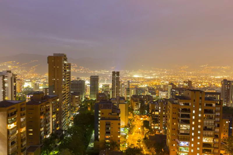 Aerial view of Medellin at night with residential and office buildings.