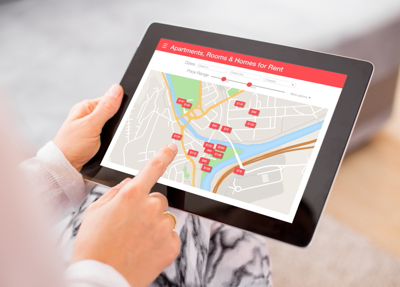 Person looking for places to stay on digital tablet app.