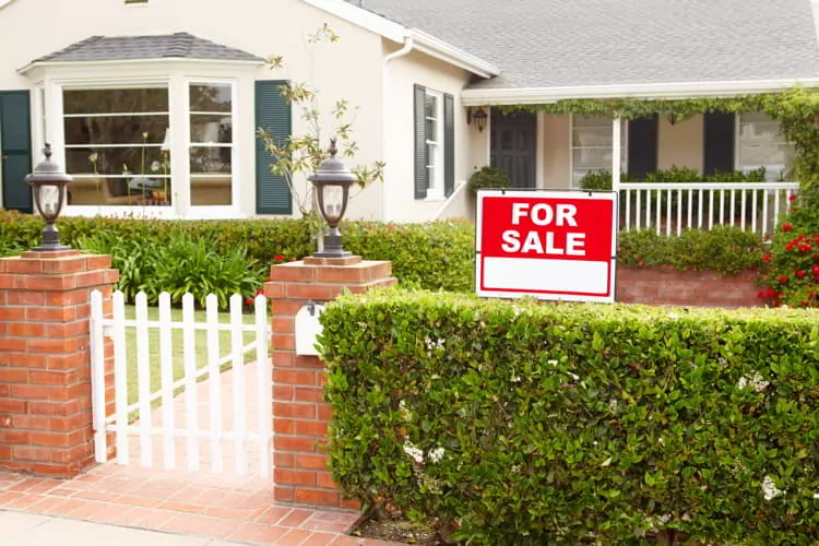 A small house with a nice green yard for sale.