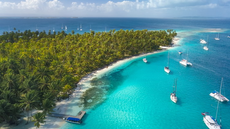 Aerial View of many Sailboats & Sailing Yachts anchored in turquoise Water of San Blas, Panama