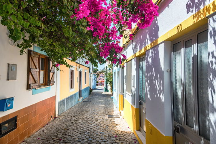 Colorful houses and pink flowers in Ferragudo, Portugal