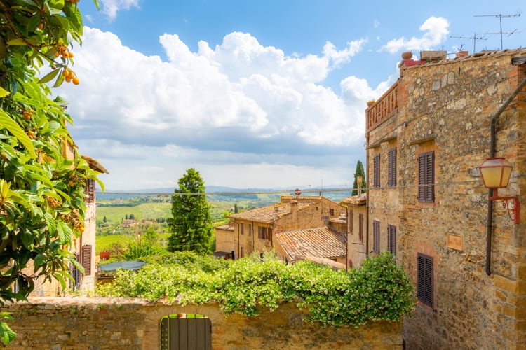 View of the hills and Tuscan countryside over the medieval hilltop village of San Gimignano, Italy.