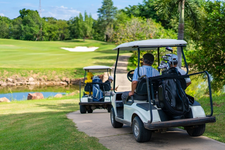 Senior Man Driving Golf Cart in Summer. investing golf overseas