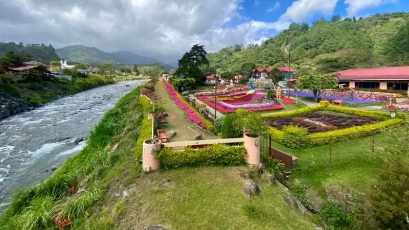 Colorful flower gardens along a river with lush mountain scenery in Boquete.