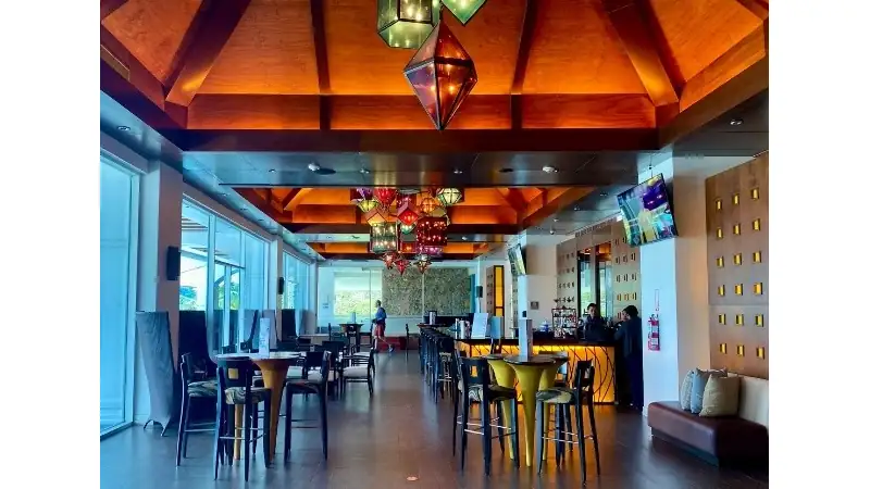 The Westin Playa Bonita’s elegant lobby features warm wooden ceilings, colorful pendant lighting, modern seating, and a welcoming lounge atmosphere.
